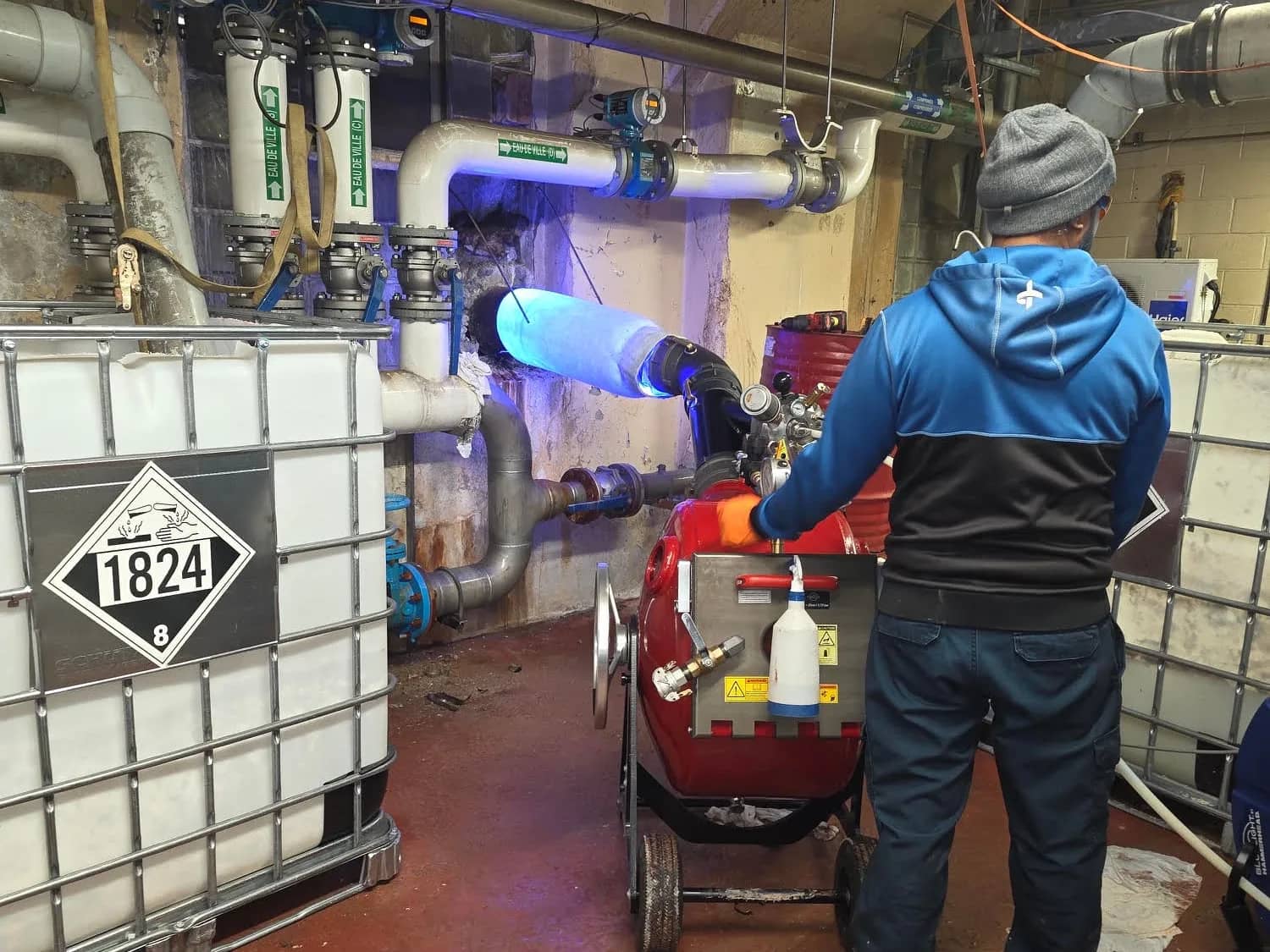 JFA technician monitoring the LED light curing of the liner in an industrial mechanical room
