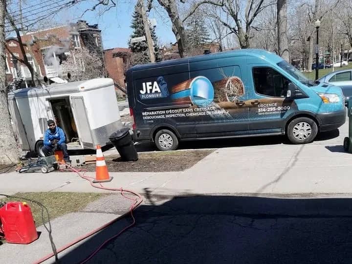 JFA Plomberie van and equipment trailer in front of a home during trenchless lining