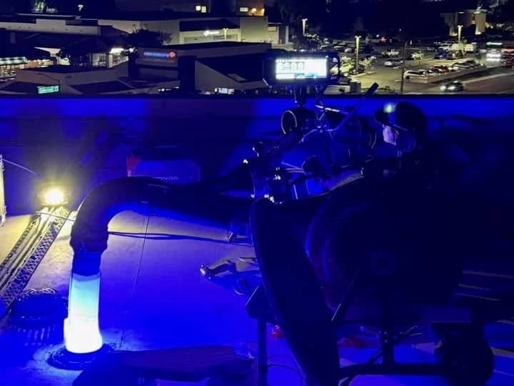 Liner glowing blue while it cures in the storm drain, on a building roof at night