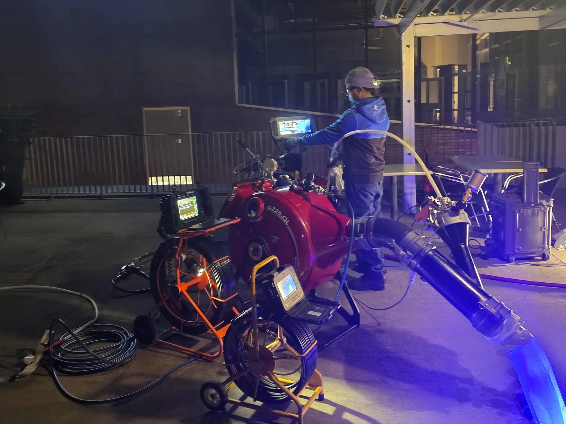 Inversion unit, camera reels and control screens set up at night in front of a commercial building