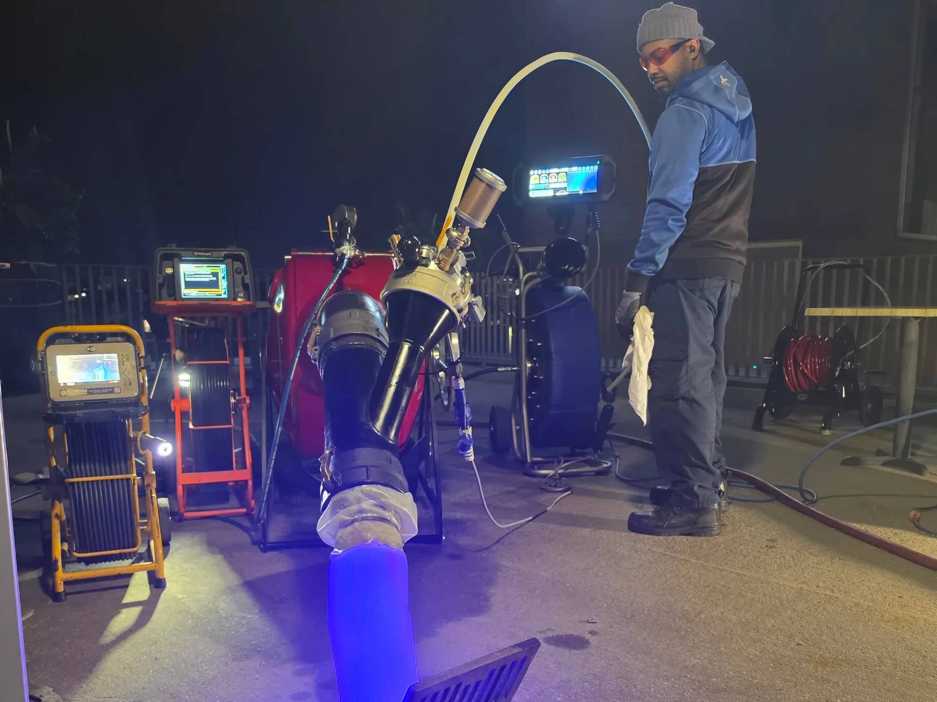 JFA technician next to the inversion unit, the liner glowing blue while it cures in the drain