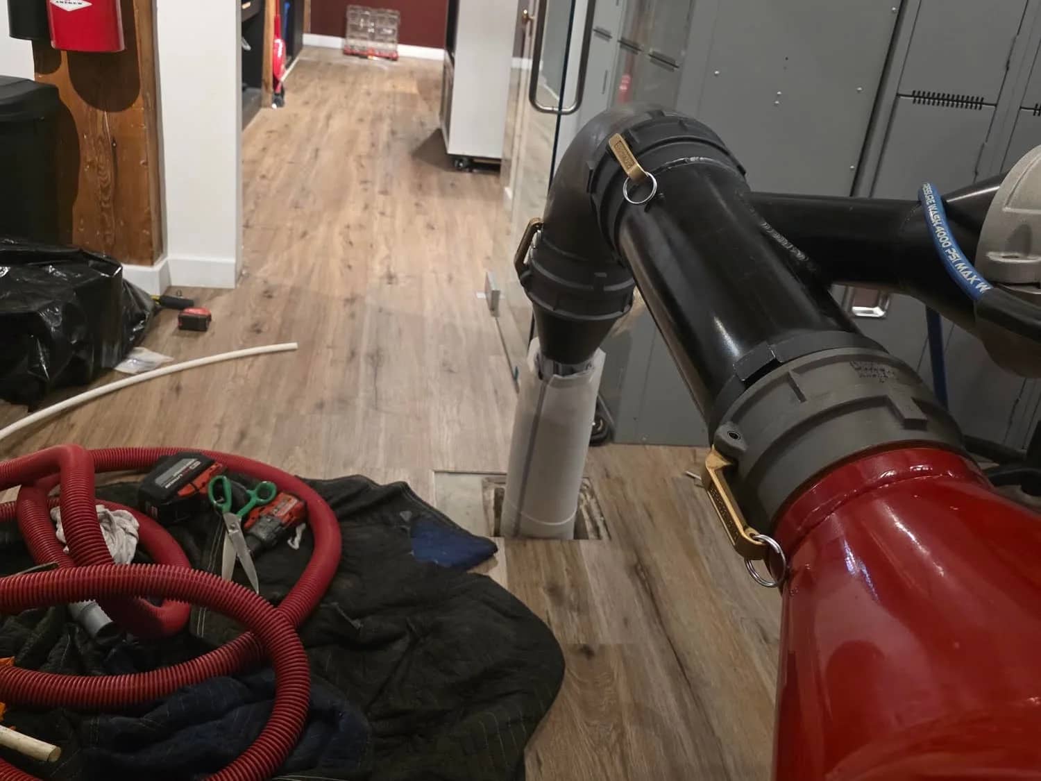 Liner inversion unit connected to the floor drain of an office hallway, floors protected
